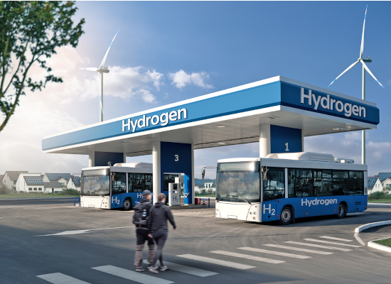 Two people walking towards a hydrogen station with two parked buses.