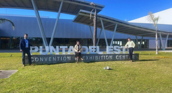 three people standing in front of the convention center in uruguay