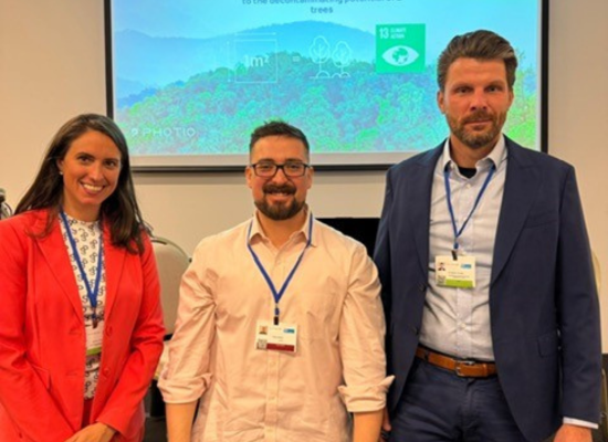 two men and one woman smiling at the camera