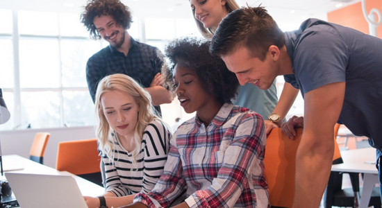 group of people around a lap top