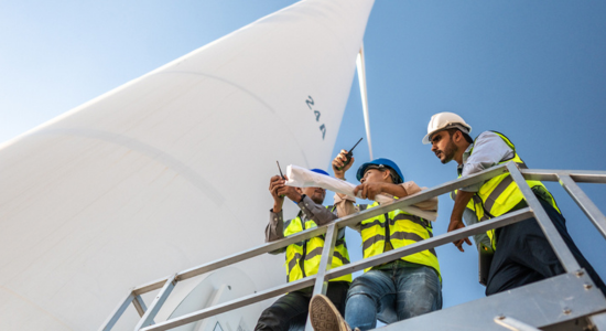 Workers standing on a wind wheel